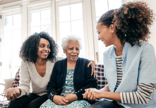 Elderly woman with two younger women smiling in a group