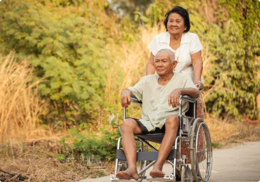 A woman pushing a man in a wheelchair