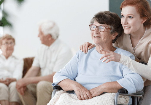 Woman in wheelchair with caretaker behind them