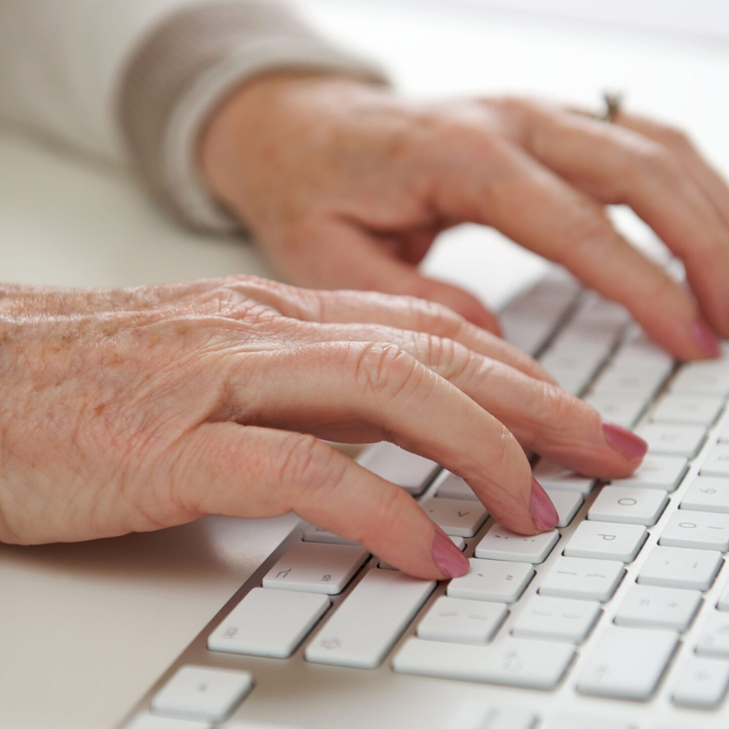 Older woman typing on keyboard