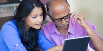 Woman and man stare at laptop