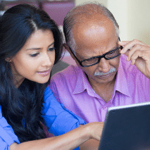 Woman and man stare at laptop